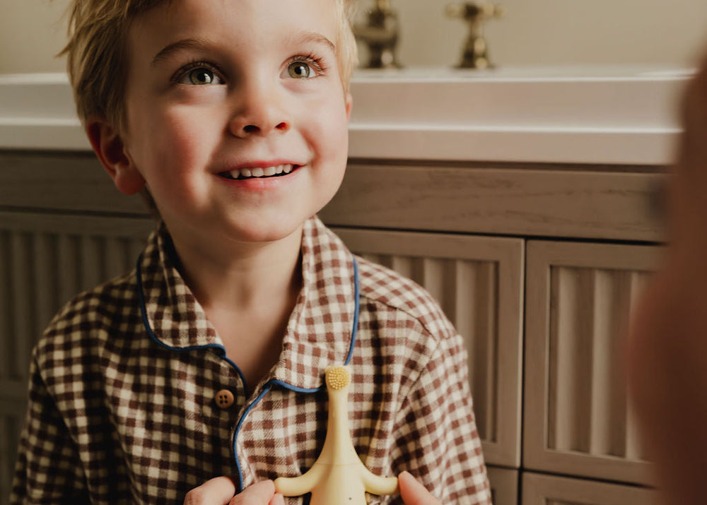 Little boy smiling in bathroom with toothbrush in pocket 